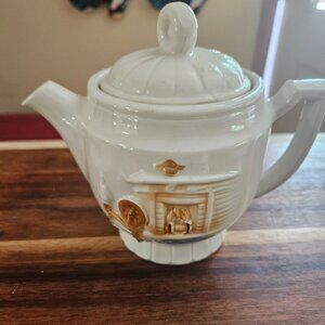 vintage porcelier teapot with distinctive hearth and spinning wheel design  193